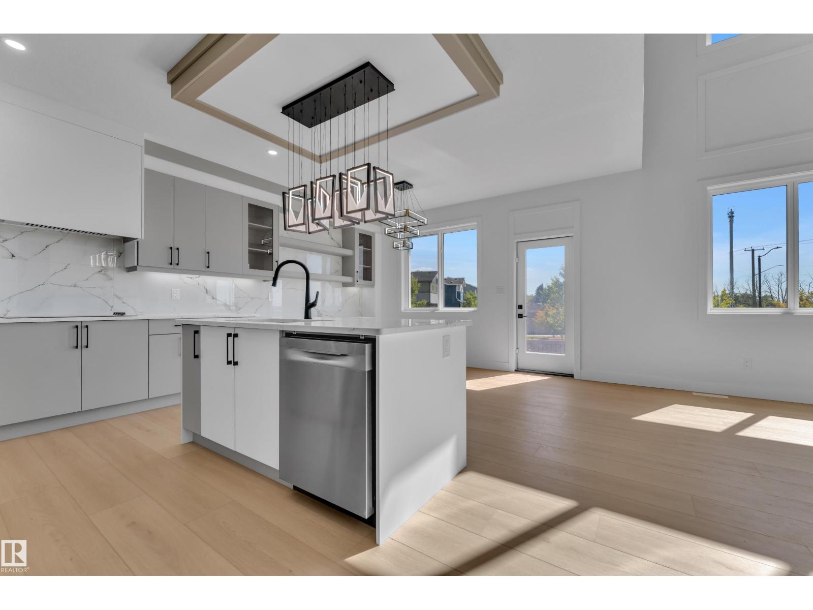 Kitchen island with pendant lighting and tray ceiling